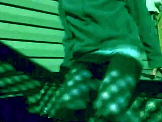 Amateur stretches in leggings outdoors at night with shadows