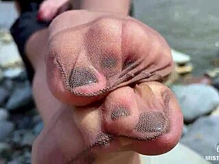 Goddess in tan nylons show her cute nylon soles and toes on the riverside