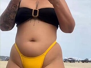 I feel excited wearing tight yellow bikini on beach showing swollen pussy